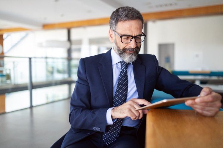 A corporate executive reviewing information on a tablet