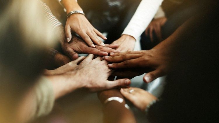 Diverse hands stacked together in a show of unity and collaboration
